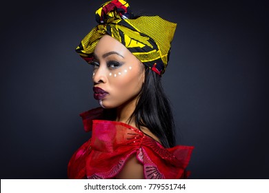 Black Female Showing African Pride By Wearing Nigerian Traditional Clothing And Tribal Makeup Or Face Painting.  The Model Is Shot In Studio In Modern Vogue Fashion Style.