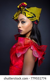 Black Female Showing African Pride By Wearing Nigerian Traditional Clothing And Tribal Makeup Or Face Painting.  The Model Is Shot In Studio In Modern Vogue Fashion Style.