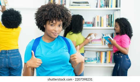 Black Female Student Showing Thumb Up With Group Of African American College Students Indoors At Library