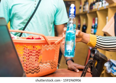 black female supermarket attendant using a barcode scanner to checkout a customer's item