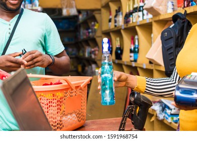 black female supermarket attendant using a barcode scanner to checkout a customer's item