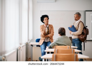Black female teacher having consultations with adult students after a class at lecture hall. 