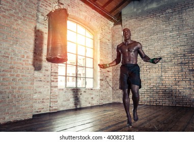 Black fighter training hard in his gym. Man using rope in an old gym,making warm up. concept about sport - Powered by Shutterstock