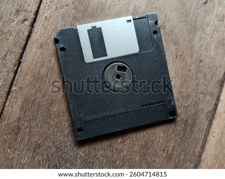 Black floppy diskette on nature wooden background. vintage disk