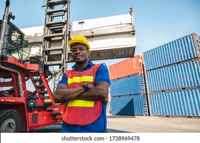Black foreman worker working control the crane and forklift at Container cargo harbor to loading containers. African dock male staff for Logistics import export shipping concept.