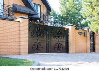 Black forged automatic gates in the cottage