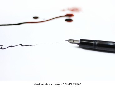 A Black Fountain Pen And Red Ink Drops On White Paper Background