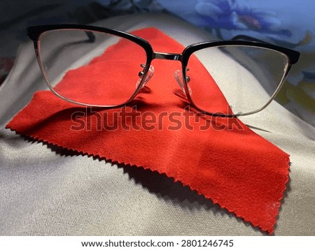 Black frame glasses on a red base