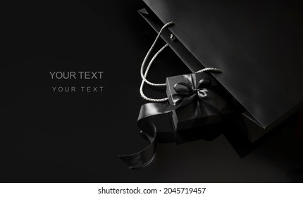 Black Friday background. Elegant black gift box with a bow ribbon near the black package. Black Friday sale template with a copy space. - Powered by Shutterstock