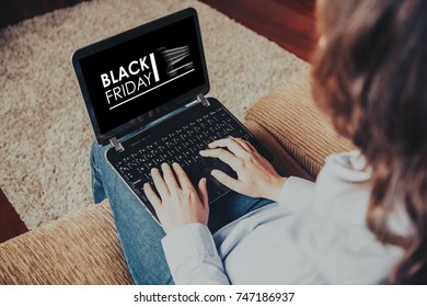 Black Friday Banner In A Laptop. Woman Using A Computer To Buy By Internet Sitting At Home.