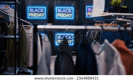 Black friday best deals on products. Modern clothing items being on promotion, various brands merchandise. Empty shopping center filled with red price tags, november discount offers.
