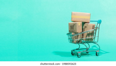 black friday concept, paper boxes parcel in a trolley isolated on green background. service home delivery. - Shutterstock ID 1988592623