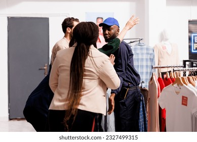Black Friday madness. Rude aggressive people fight with fashion store security while waiting for sales, stressed African American security guard controlling entrance of shopping mall