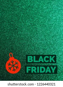 Black Friday On Green Glitter Background With A Red Ornament.