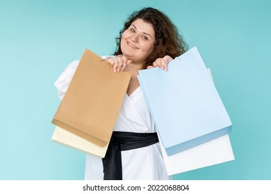 Black Friday. Plus Size Woman. Enjoying Shopping. Hot Sale. Festive Discount. Beautiful Happy Fatty Lady Holding Many Purchase Bags Feeling Joy Isolated Blue.