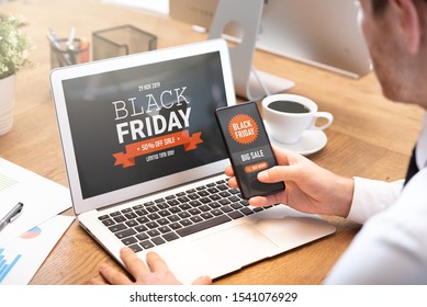 Black Friday Promotion Sale On Laptop And Phone Screen. Young Man Doing Shopping Online