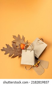 Black Friday Sale Concept. Shopping Paper Bags, Handmade Tags, Fall Oak Leaves, Autumn Decor. Light Background, Flat Lay, Top View