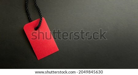 Black Friday Sale or Discount banner. Red clothes tag over black background. Modern minimal design with space for text. Template for promotion, advertising, web, social and fashion ads. High quality