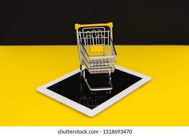 Black Friday Sales. Small Shopping Trolley On A Tablet In Yellow Background. Cybermonday Concept