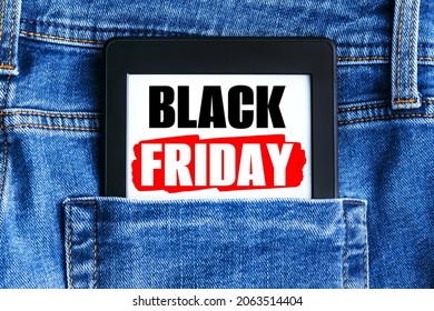 Black Friday Sign On Electronic Book Or Tablet In The Back Pocket Of Blue Denim Jeans. Shopping Concept