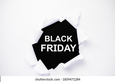black Friday is written on a black background in the center of a torn white paper.
