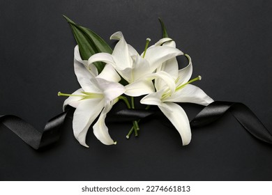 Black funeral ribbon and white lily flowers on dark background - Powered by Shutterstock