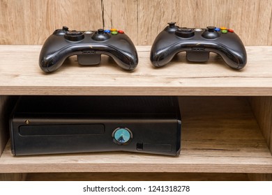 Black game console and controller the table. Game console and gamepad lying on the table