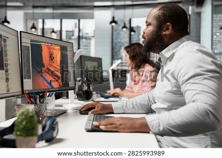 Black game developer uses programming and modeling software to create a futuristic space video game with spaceships, stations and automated virtual assets