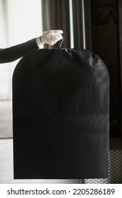 Black Garment, Suit Travel Bag. The Hands Of A Hotel Worker In White Gloves.