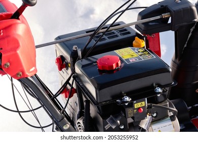 Black Gas Tank Of A Snowblower On A Background Of Snow. Close-up. Black, White, Red. Yellow Safety Instructions.