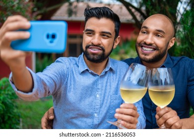 Black Gay Couple Taking Selfie With Mobile And Glass Of Wine Outside In The Garden