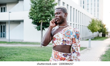 Black Gay Person In Feminine Clothes Speaking On Smartphone