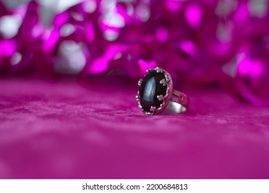 Black Gem Stone Ring With Pink Background