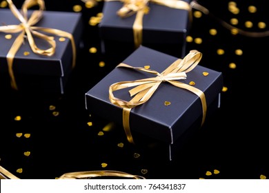 Black Gift Boxes With Gold Ribbon On Shine Background. Close Up