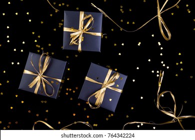 Black Gift Boxes With Gold Ribbon On Shine Background. Flat Lay