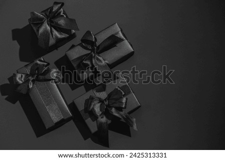 Black gift boxes on a dark black background with space for text.