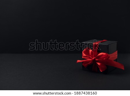 Black gift boxes with red ribbon on black background with copy space for text. The Concept Of Valentine's Day.