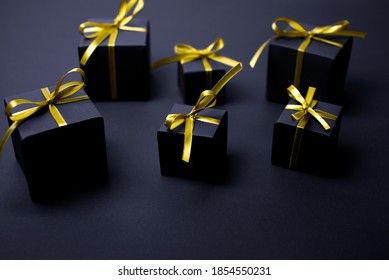 Black gifts with gold ribbons.Set of gift box isolated on black background.Christmas gift boxes on black background. Merry Christmas and Happy Holidays greeting card, frame, banner. black friday