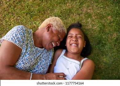 Black Girl And Grandmother Lying On Grass, Overhead Close Up