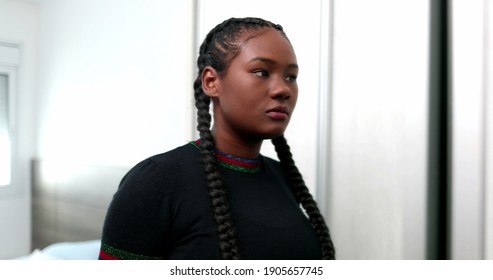 Black Girl Preparing Hair In Front Of Mirror. African Teen Looking At Herself In Glass Reflection