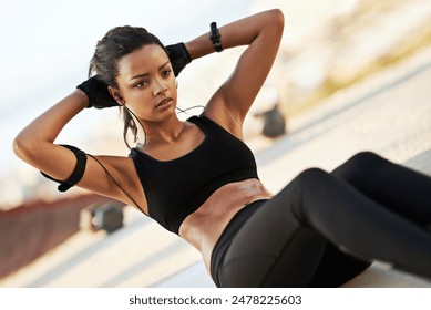 Black girl, sit ups and music to exercise in outdoor, strong core and workout for six pack or muscle. Female person, earphones and active for abs, fitness and athlete for crunches or training - Powered by Shutterstock