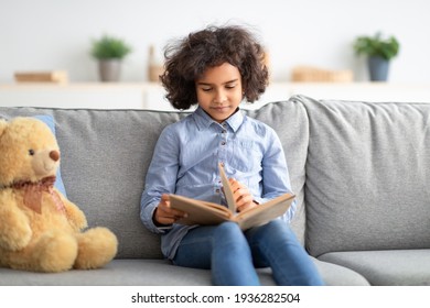 Black Girl Sitting On The Couch, Reading Book