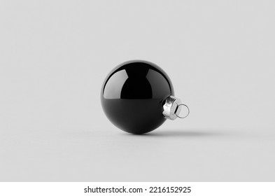 Black glossy Christmas ball mockup on a seamless grey background.