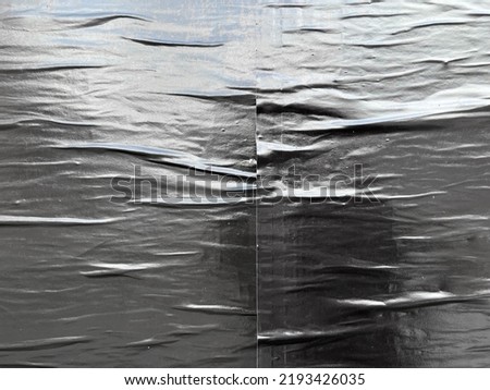 Black glossy sheeny paper glued urban wrinkled street poster texture