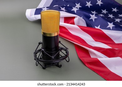Black and gold studio microphone next to an American flag on a green background. In this state of silence the voice is heard, concept.