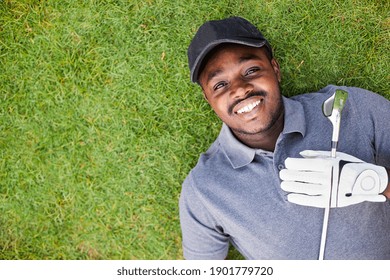 A Black Golfer Lying On The Green Grass.