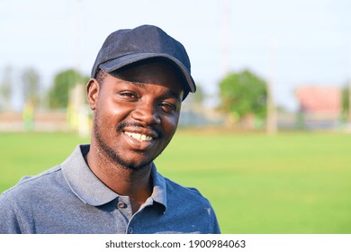 Black Golfer Wearing Sport Hat Standing In An Outdoor Golf Course.