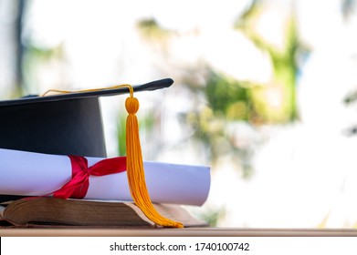 A black graduation cap and a certificate placed on an old book - Shutterstock ID 1740100742