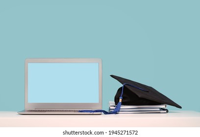 Black Graduation Cap With Notebooks And Laptop. Masters Or Bachelors Degree Thesis Writing. Knowledge Online Courses Qualifications And Higher Education With Copy Space. Lockdown. Mock Up Screen