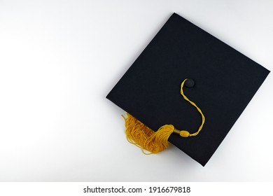 Black graduation cap on a white background, copy space. Academic hat, graduation concept